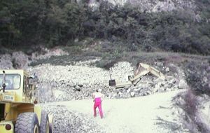 Un volontario si incammina tra le macerie della cava